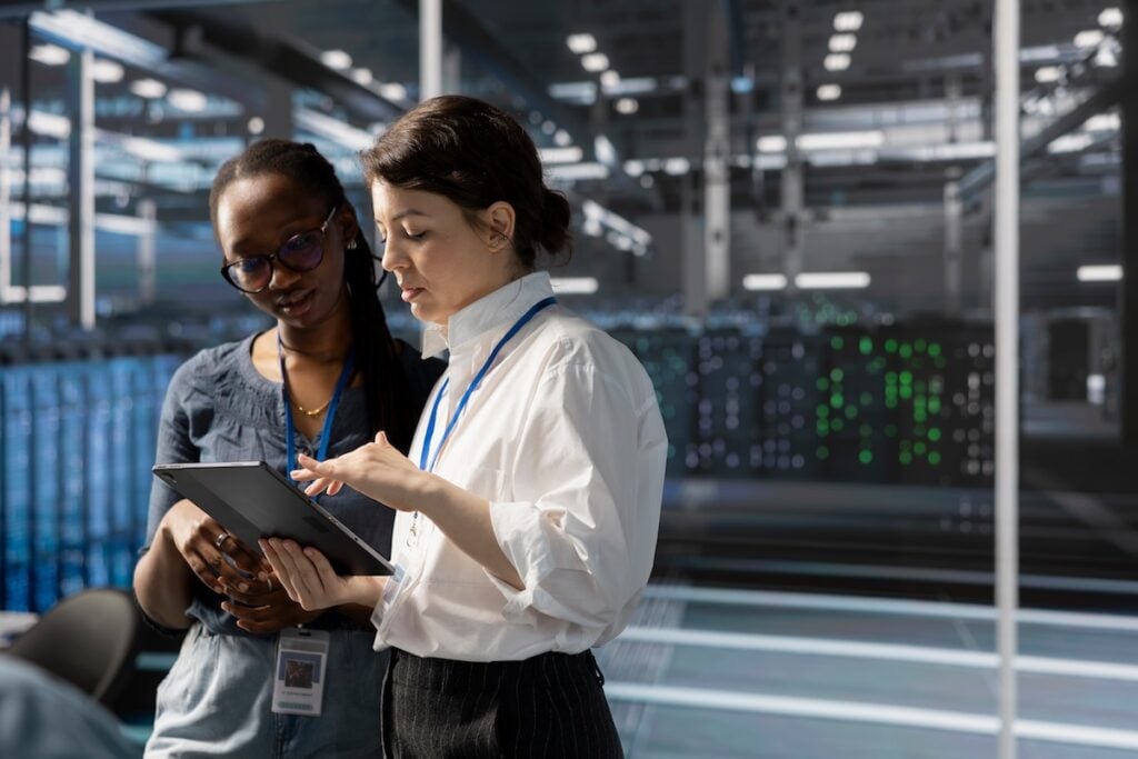 Engineers in data center using device, verifying firewall configurations.