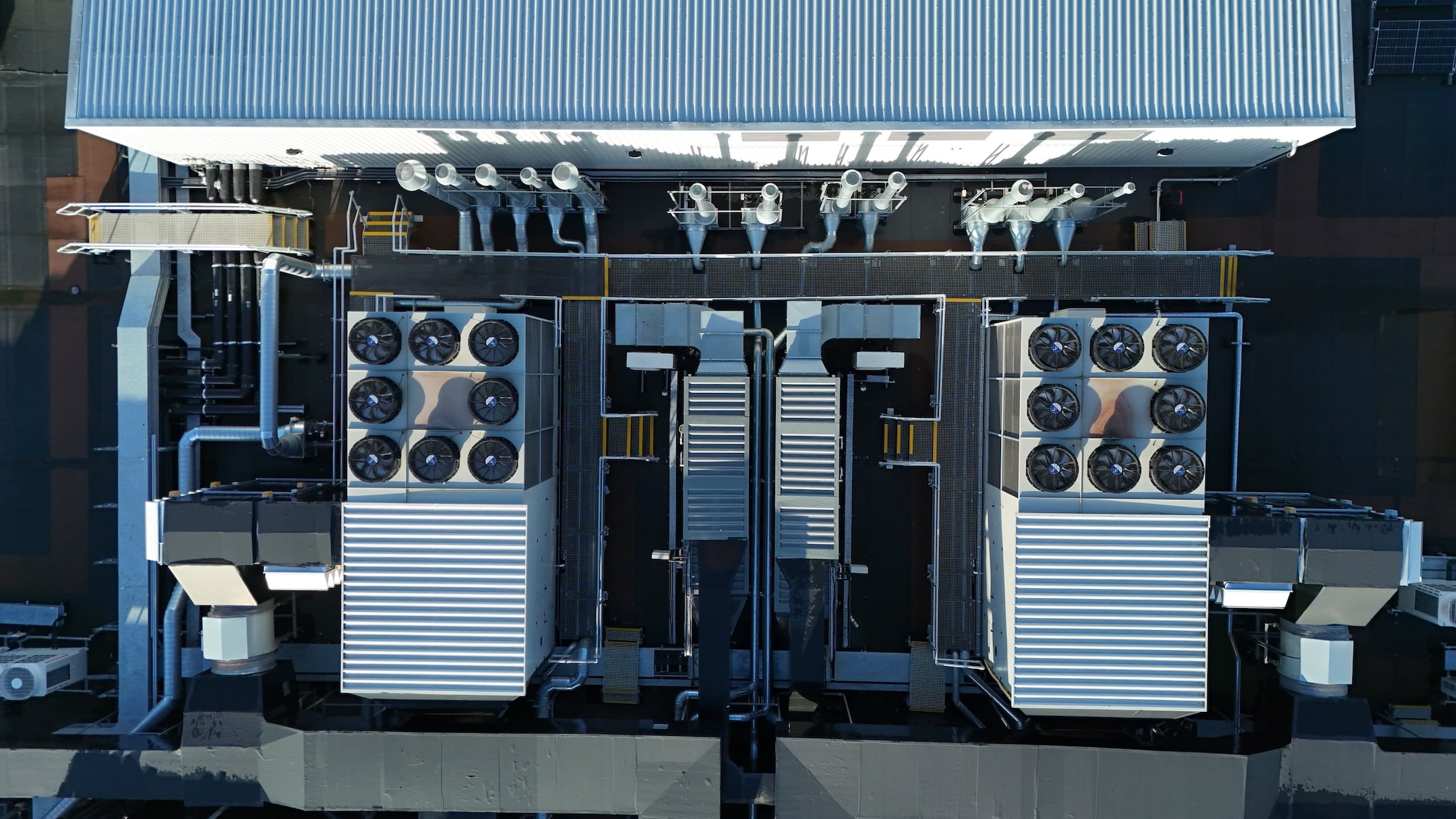 Aerial drone top down rotating view of cooling and ventilation systems on a data storage center warehouse building showing modern infrastructure.