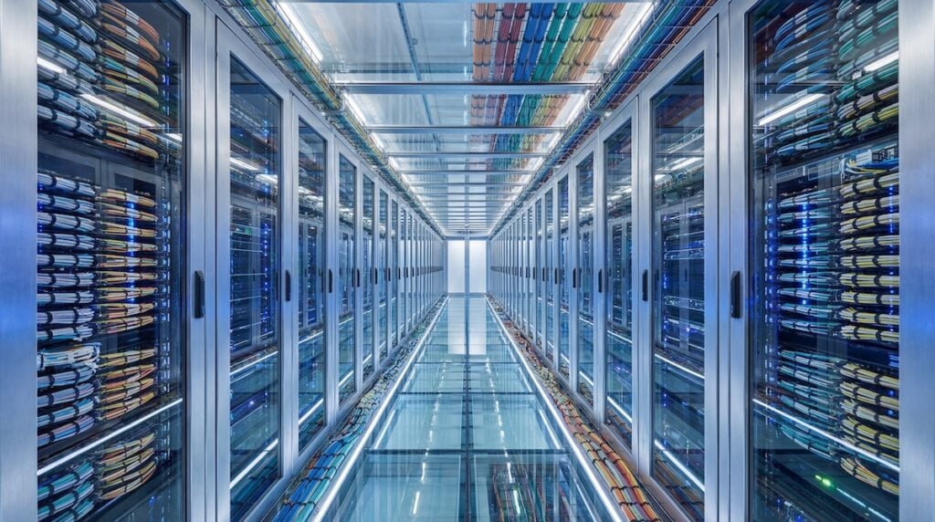 Modern Data Center Server Room with Rows of Racks and Cables.