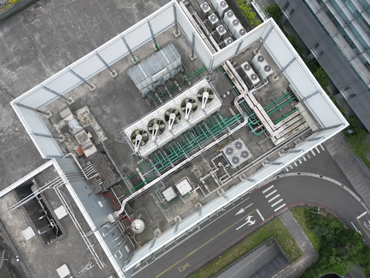 Aerial top-down view of complex cooling towers and piping for an AI data center