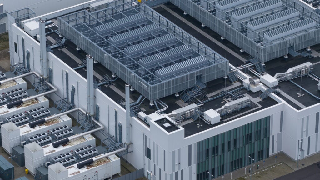 crac unit Large data center building from an aerial perspective, featuring a complex array of modern cooling units, ventilation systems, and industrial hvac infrastructure on its expansive rooftop and side