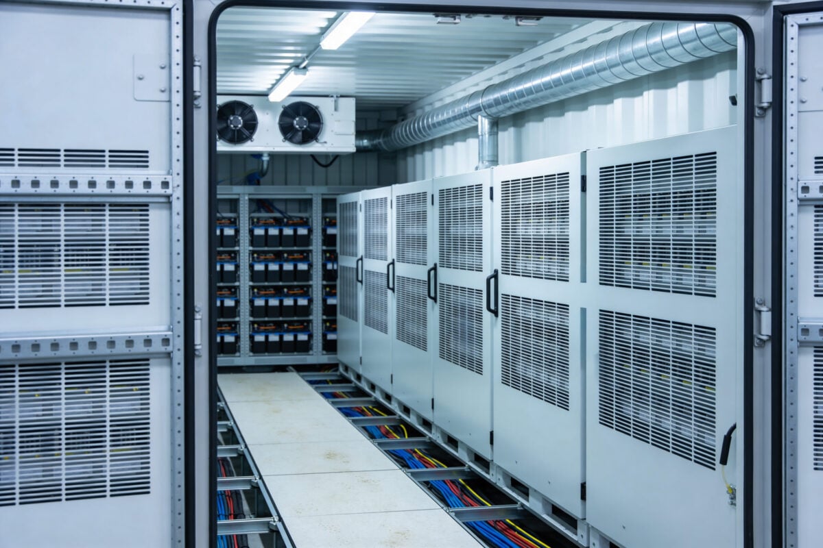 crac unit A view inside a climate-controlled containerized data center featuring rows of server cabinets and a battery backup system with visible cabling
