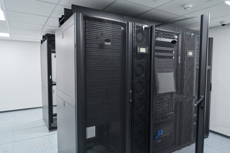 data center cooling solutions Secure, modern data center interior showing black server racks, network switches and cooling units in a clean, climate-controlled server room for enterprise IT infrastructure and cloud services.